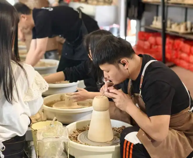 A potter throwing a vessel on the wheel in a Jingdezhen workshop