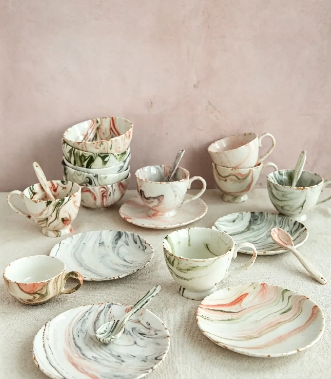 A full hand-painted botanical dinner service arranged on a blush background